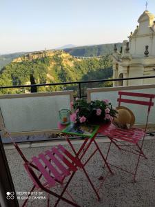 2 sedie e un tavolo con fiori sul balcone di Terrazza del Poggio a Lubriano