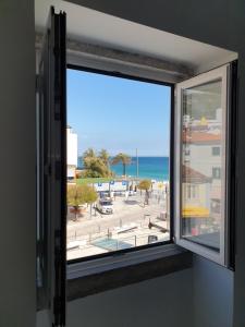 uma janela com vista para a praia em Casa da Tia em Sesimbra mais 8 fotografias