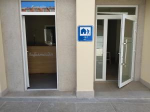 a sign on the side of a building with two doors at Albergue & Rooms Murgadán in Padrón