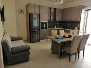 uma cozinha com uma mesa e cadeiras e um frigorífico em Eleni Apartment em Perdika