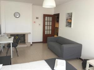 a living room with a couch and a clock on the wall at APARTAMENTO LISBOA - REBOLEIRA in Amadora