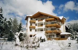 a large building with snow on the ground at Landhotel Eva in Kirchberg in Tirol