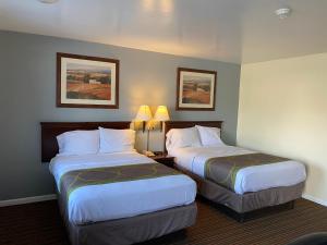 a hotel room with two beds and two lamps at Relax Inn in Brunswick
