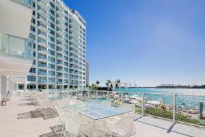 uma varanda com mesas e cadeiras ao lado de um edifício em Mondrian South Beach em Miami Beach