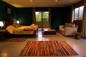 - une chambre avec un lit, une chaise et un tapis dans l'établissement Lodge del Maipo, à San José de Maipo