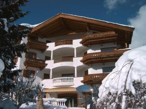 ein großes Gebäude mit Schnee auf dem Boden in der Unterkunft Landhotel Eva in Kirchberg in Tirol