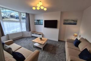 a living room with a couch and a coffee table at Beautiful Seaside Apartment With Parking in Ventnor