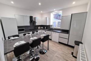 a large kitchen with a table and chairs in it at Beautiful Seaside Apartment With Parking in Ventnor