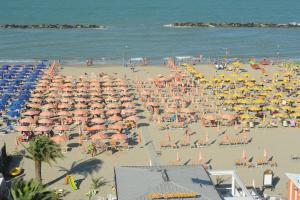 una playa llena de sombrillas y gente en Hotel Altis, en San Benedetto del Tronto