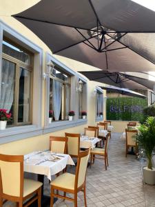 a restaurant with tables and chairs under an umbrella at Hotel La Pace in Pontedera