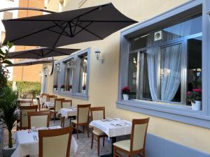 a restaurant with tables and chairs and an umbrella at Hotel La Pace in Pontedera