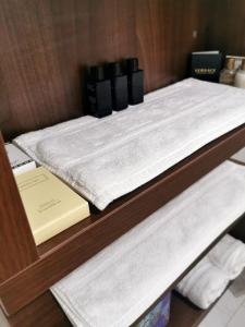 two white towels and a book on a shelf at Apartman Centar in Aleksandrovac