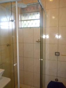 y baño con ducha y puerta de cristal. en Casa do Passarinho, en Campos do Jordão