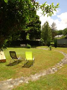 dos sillas sentadas en el césped en un patio en Maison individuelle "Gite la Soulane" à 2 min de Saint lary soulan, en Vielle-Aure