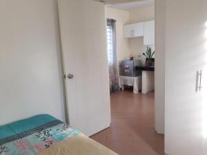 a white room with a bed and a kitchen at Rent! Monthly or More in San Juan