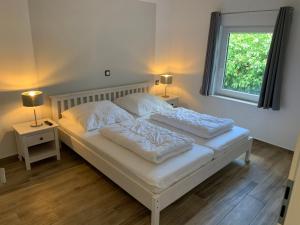 a white bed with two pillows on it in a bedroom at Quartier Usedom in Ostseebad Karlshagen