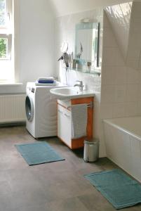uma casa de banho com um lavatório e uma máquina de lavar roupa em Ferienwohnung Werenberg Goslar em Goslar