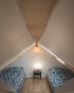 2 camas en un dormitorio en el ático con mesita de noche en Maison individuelle "Gite la Soulane" à 2 min de Saint lary soulan, en Vielle-Aure