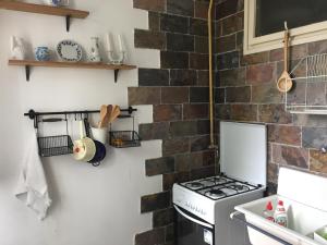 a kitchen with a brick wall and a stove at Jednopokojowe mieszkanie w centrum Gdyni in Gdynia