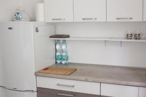 a kitchen with white cabinets and a white refrigerator at Jednopokojowe mieszkanie w centrum Gdyni in Gdynia