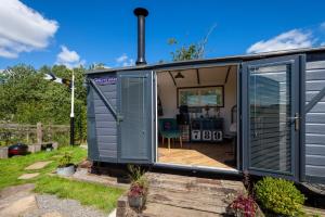 ein winziges Haus mit einer Tür in einem Hof in der Unterkunft Skipbridge Farm Glamping in Green Hammerton