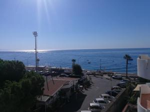 a parking lot with cars parked next to the ocean at B&B Il Mare degli Dei in Letojanni