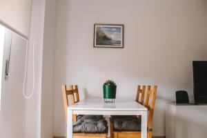 una pequeña mesa blanca con 2 sillas y una planta en Caparica Sunny House II, en Costa da Caparica