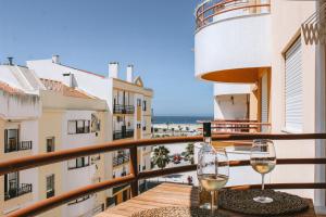 balkon z dwoma kieliszkami wina na stole w obiekcie Caparica Sunny House II w Costa de Caparica