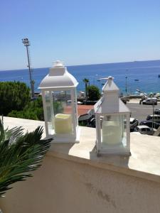 two white lanterns sitting on a ledge near the ocean at B&B Il Mare degli Dei in Letojanni