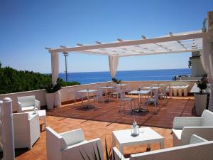 a patio with tables and chairs and the ocean at B&B Il Mare degli Dei in Letojanni