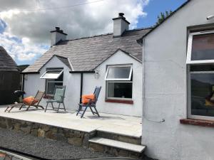 a group of chairs sitting outside of a house at Rooneys @ Ballymagreehan Explore and Unwind in Castlewellan