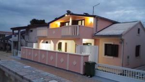 een roze huis met een wit hek ervoor bij Gizmo in Vir