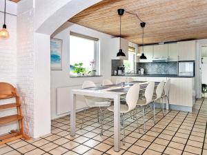 a kitchen and dining room with a white table and chairs at Four-Bedroom Holiday home in Bogense 3 in Skåstrup