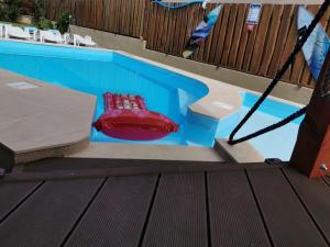 una silla roja sentada en una piscina en House4U, en Balatonszemes