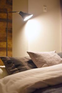 a bedroom with a bed with a lamp on the wall at REGALO Shibaura - Vacation STAY 88351 in Tokyo