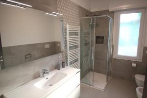 uma casa de banho com um lavatório e uma cabina de duche em vidro. em Persea mare appartamenti em Arma di Taggia