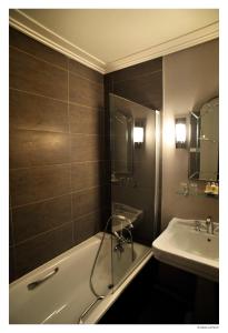 a bathroom with a bath tub and a sink at Hotel De La Treille in Lille +32 photos