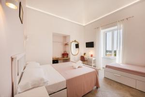 a white bedroom with a bed and a window at Villa Caterina b&b in Procida