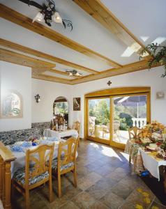 ein Esszimmer mit Tischen und Stühlen und einem großen Fenster in der Unterkunft Landhotel Eva in Kirchberg in Tirol