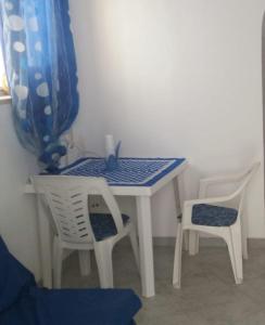 a white table with two chairs and a blue and white table at Alba Sea House in Alcamo Marina