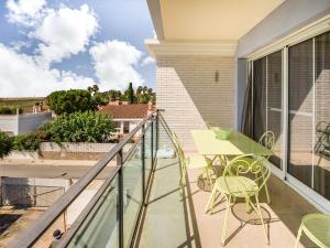 デルテブレにあるComfortable Apartment in L Eucaliptus with Swimming Poolのバルコニー(テーブル、椅子付)