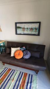 ein braunes Sofa mit Kissen darauf im Zimmer in der Unterkunft BEIRA MAR APTO 711 in Ubatuba