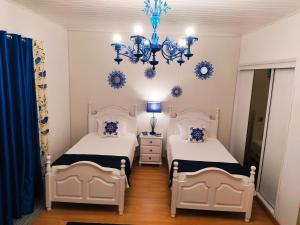 a bedroom with two beds and a chandelier at Santo Cristo House in Ponta Delgada