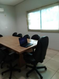 a room filled with desks and chairs with a laptop on one of them at Hotel Executivo in Araguaína