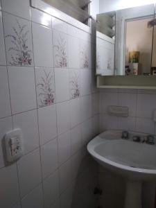 Baño blanco con lavabo y espejo en DEPARTAMENTO EN LOMA HERMOSA 2 en Loma Hermosa