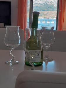 butelkę wina i dwa kieliszki na stole w obiekcie Apartments Verica w mieście Pag