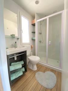 uma casa de banho com um chuveiro, um WC e um lavatório. em Mobile Home Leggiero 156 - Porton Nature Hideouts em Rovinj