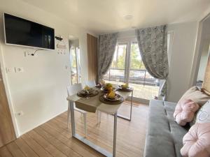 uma sala de estar com uma mesa e um sofá em Mobile Home Leggiero 156 - Porton Nature Hideouts em Rovinj