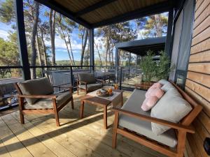 eine abgeschirmte Veranda mit einem Sofa und Stühlen in der Unterkunft Mobile Home Leggiero 156 - Porton Nature Hideouts in Rovinj