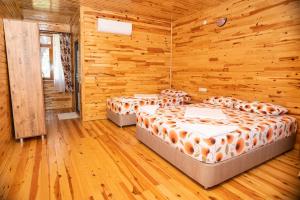 3 camas en una habitación con paredes de madera en Olimpia Hotel, en Olympos